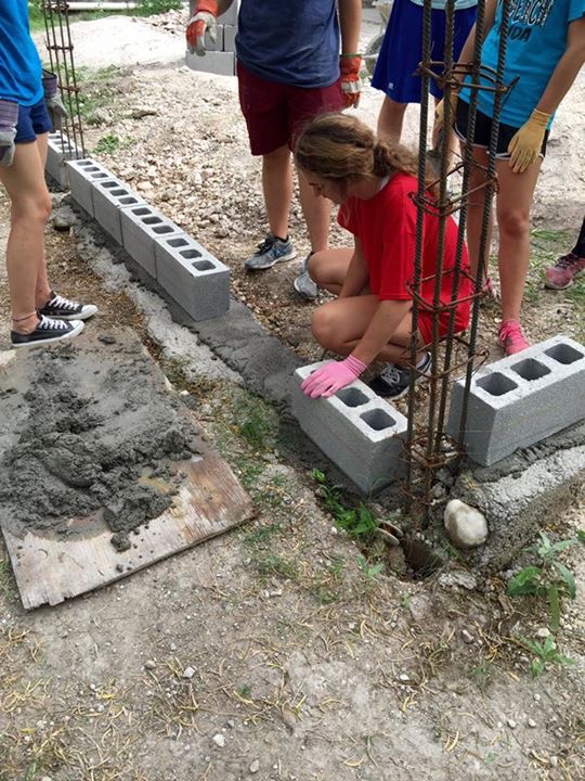 Casa Bethesda volunteers creating a perimeter of concrete bricks for their expansion