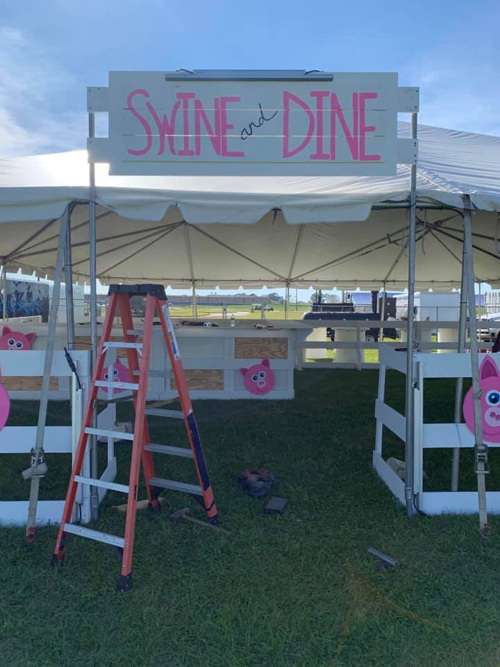 swine and dine team preparing their tent area for the festival