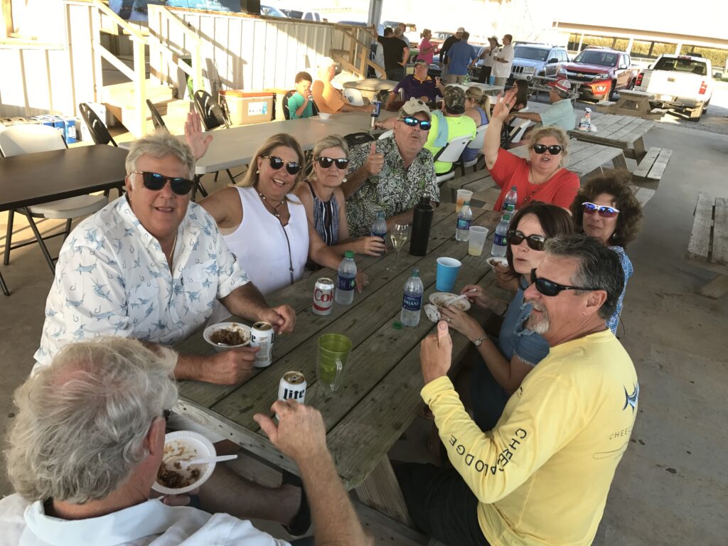 group photo at the grand isle slam of participants eating under the boat launch pavilion