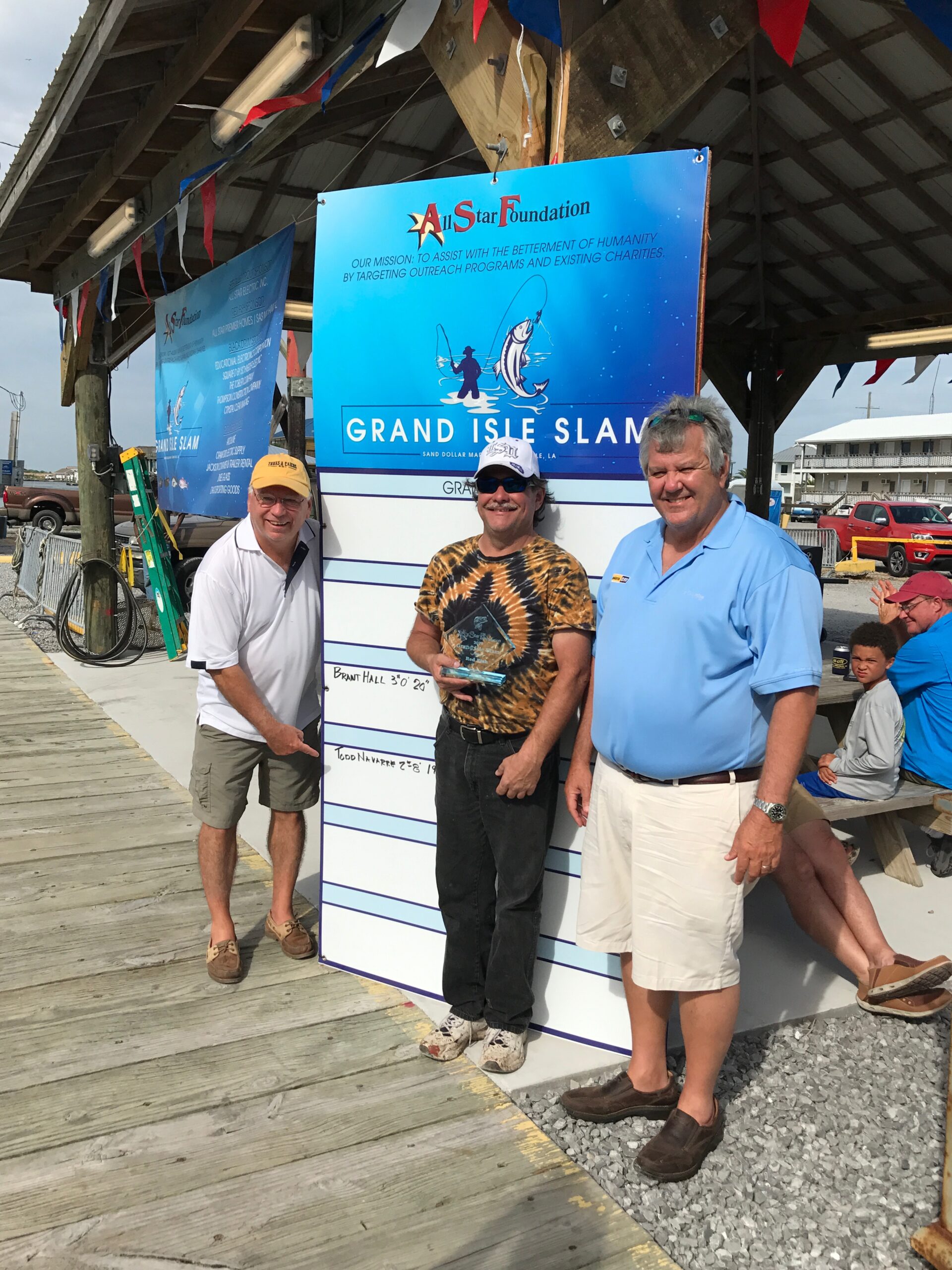 Grand isle slam trophy presentation in front of sponsor banner