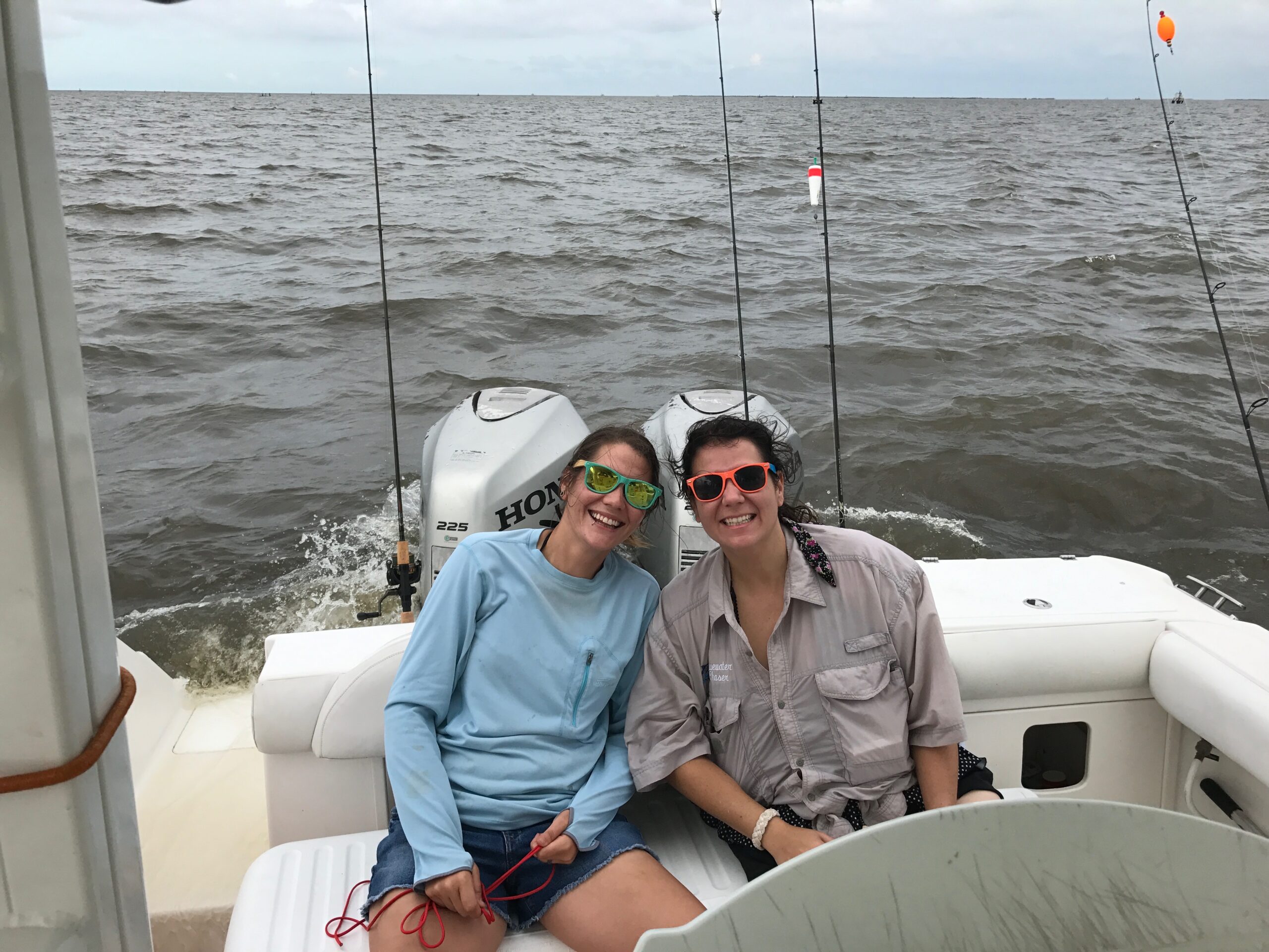 grand isle slam participants on the back of a boat smiling