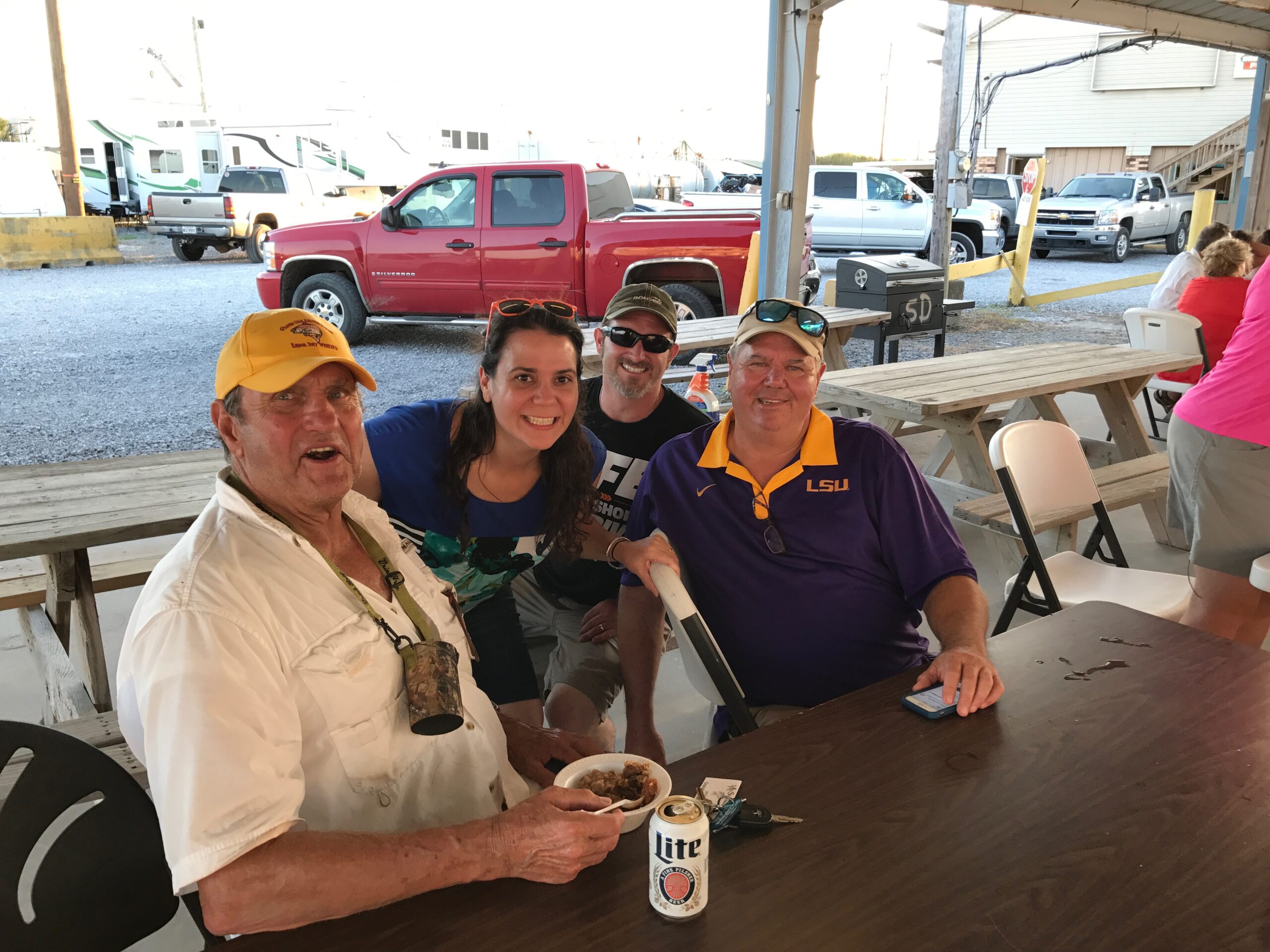 group photo of grand isle slam participants eating jambalaya at a boat launch